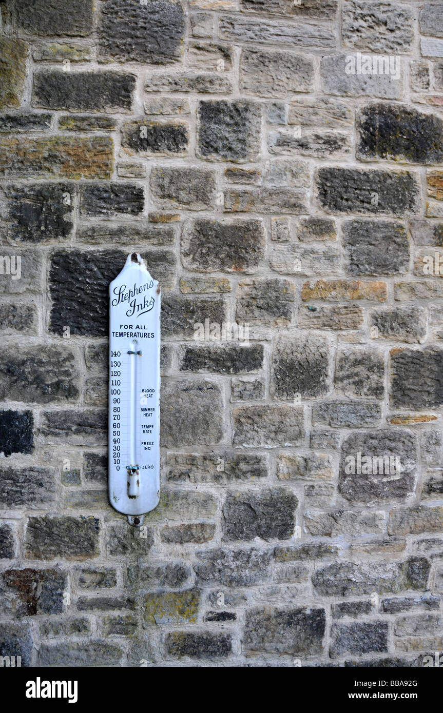 Termometro di antiquariato su un muro di mattoni Foto Stock