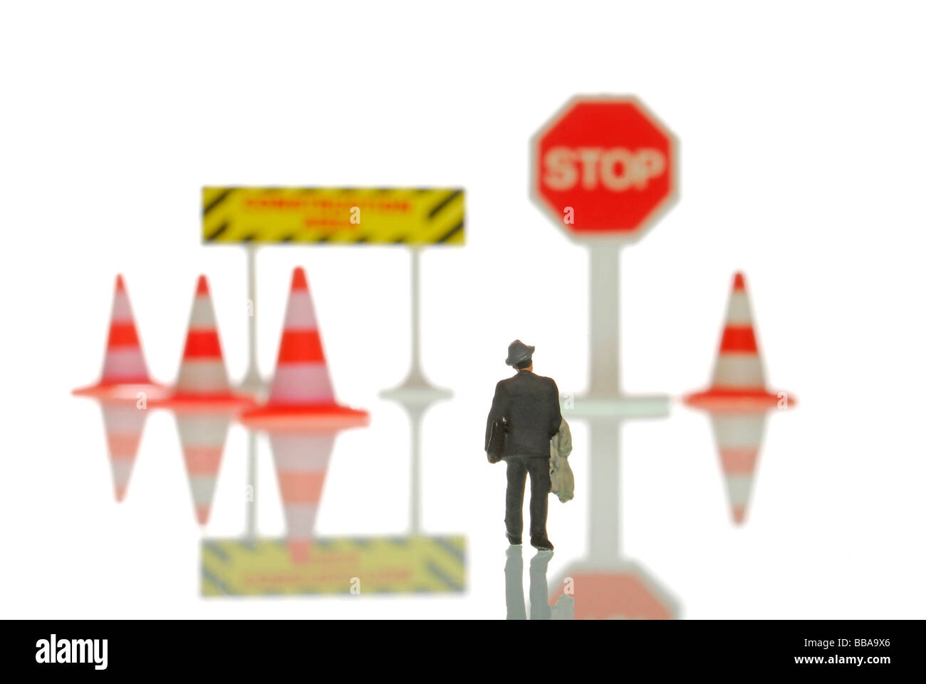 Figura in miniatura di un imprenditore a piedi verso cartelli di divieto, immagine simbolica per la voce verso una crisi Foto Stock