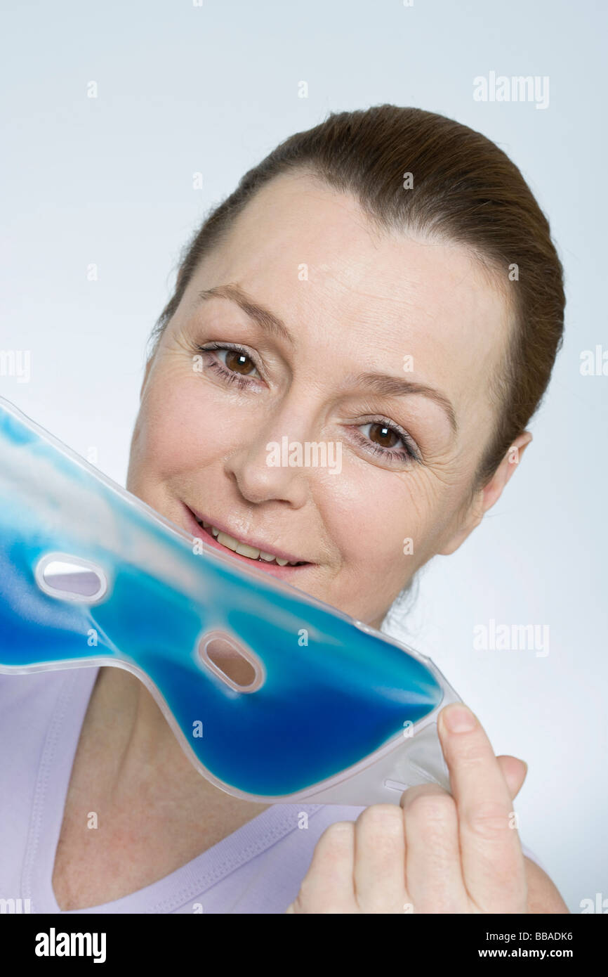 Una donna tenendo un occhio maschera Foto Stock