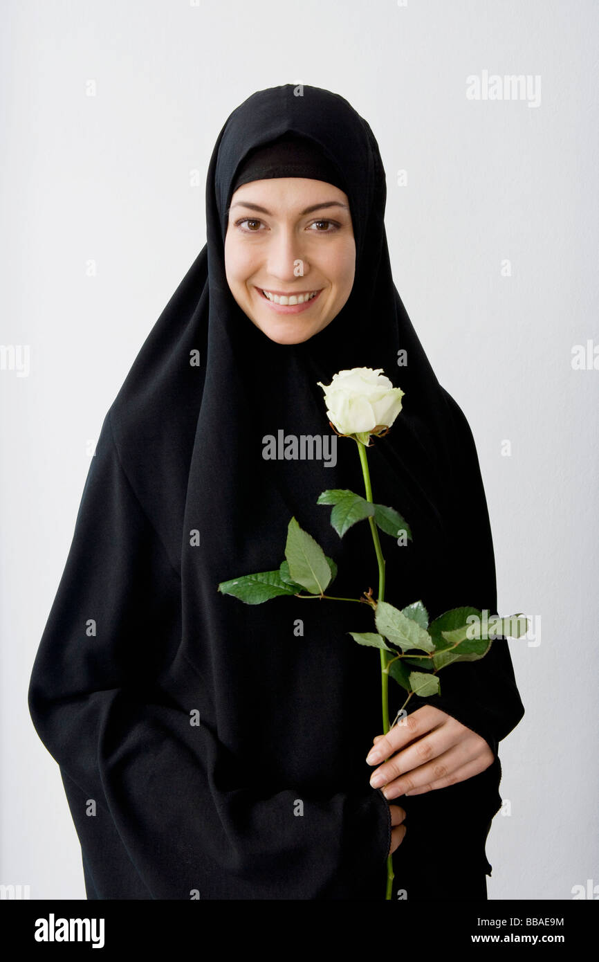 Ritratto di una donna che indossa un hijab e tenendo una rosa Foto Stock