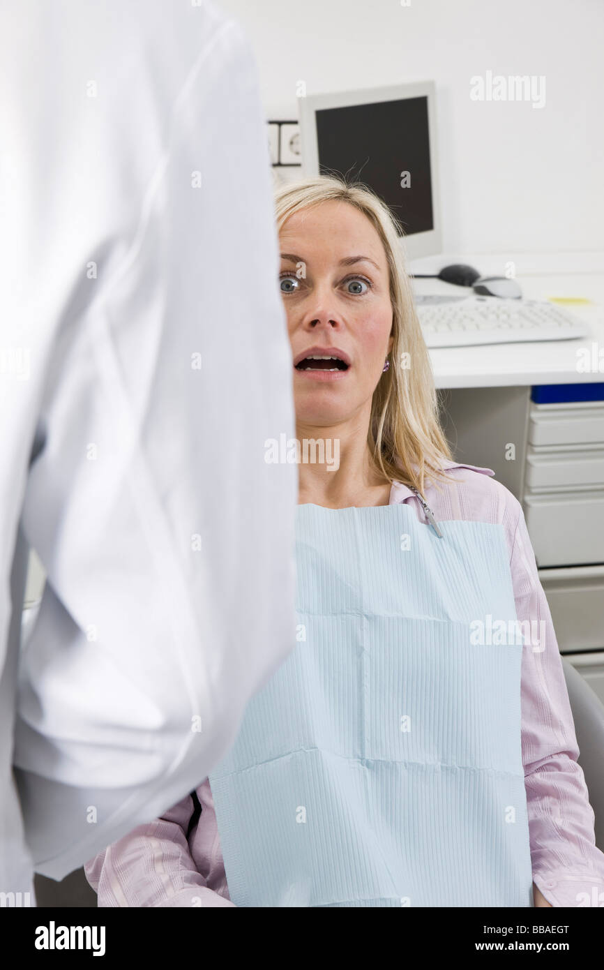 Un paziente ansioso seduta in una poltrona del dentista Foto Stock