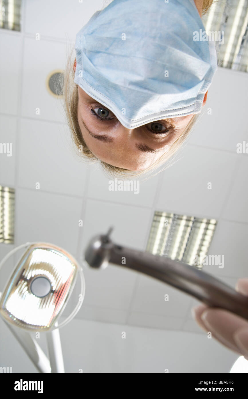 Vista dal basso di un dentista holding s drill Foto Stock
