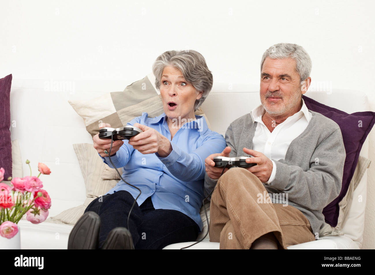 Un anziano uomo e donna senior la riproduzione di un video gioco Foto Stock