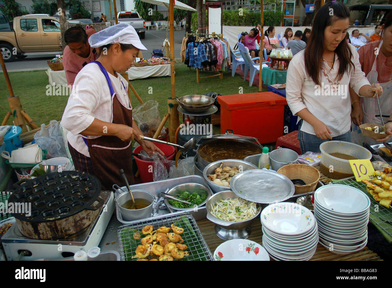 Thai Ladies la cottura di cibo di strada in un tempio buddista di Chiang Mai, Thailandia Foto Stock