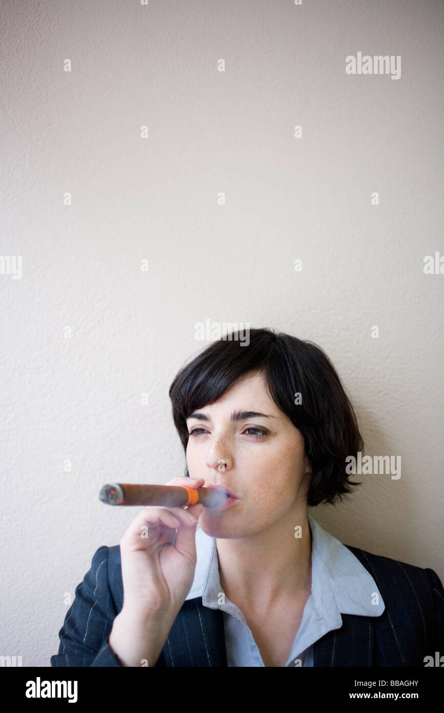 Imprenditrice di fumare il sigaro Foto Stock