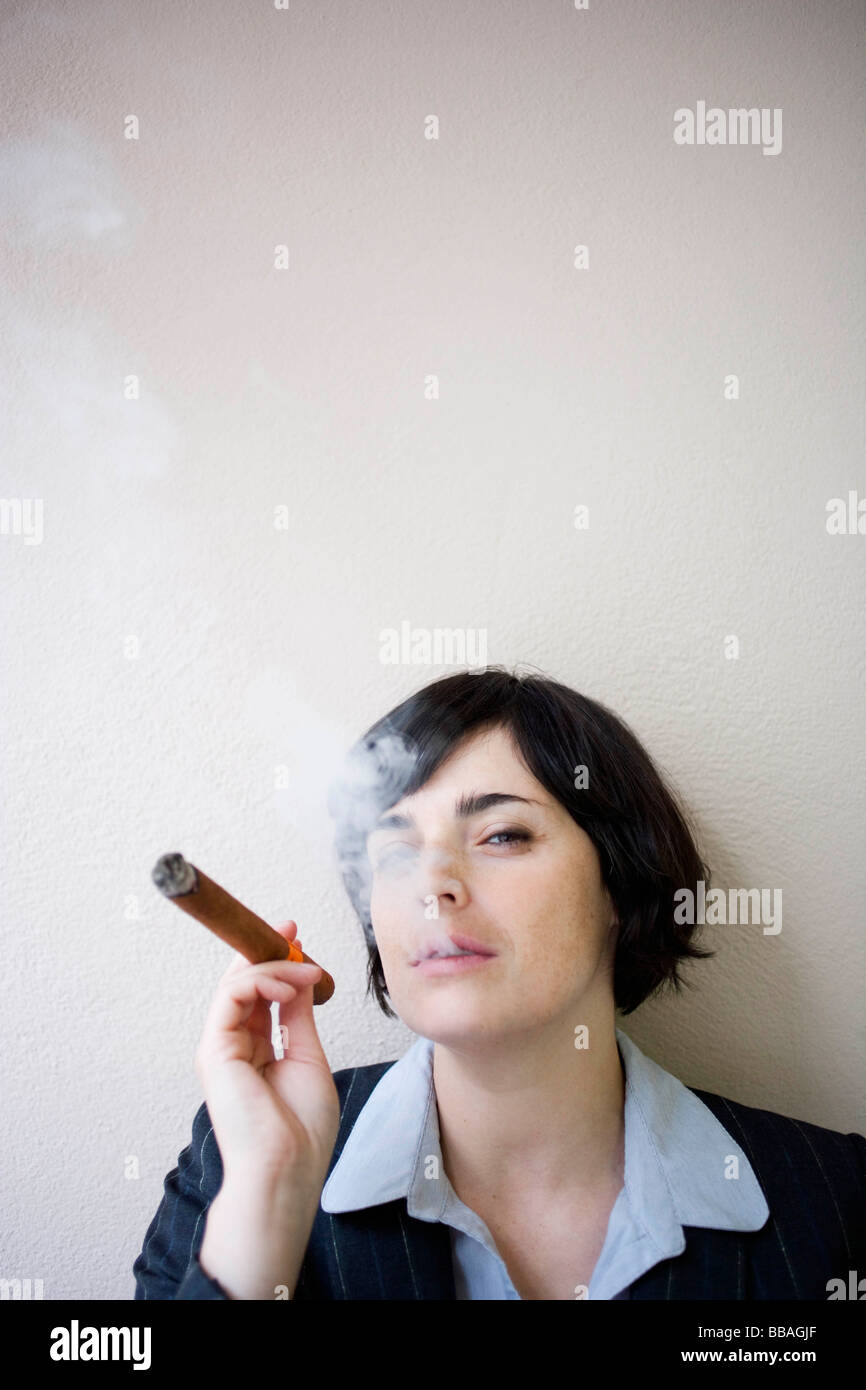 Imprenditrice di fumare il sigaro Foto Stock