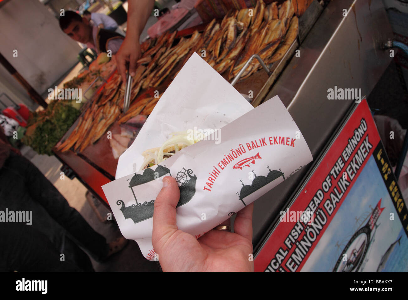 Turchia Istanbul pesce fritto di stallo alimentare cliente acquistando un pesce fritto sandwich noto come Balik Ekmek sul lungomare a Eminonu Foto Stock
