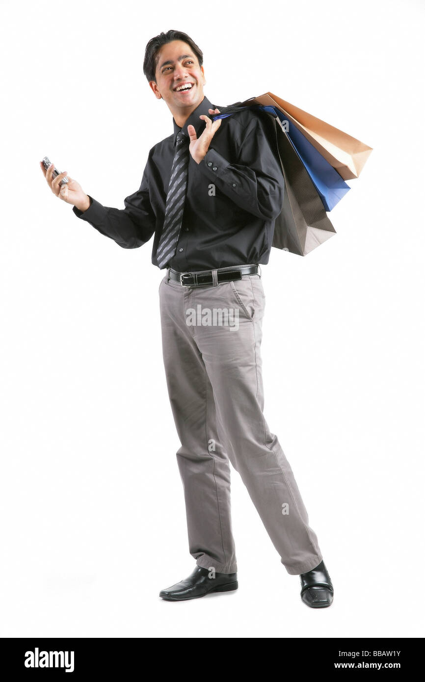 Imprenditore il trasporto delle borse della spesa sulla spalla, tenendo il telefono cellulare Foto Stock