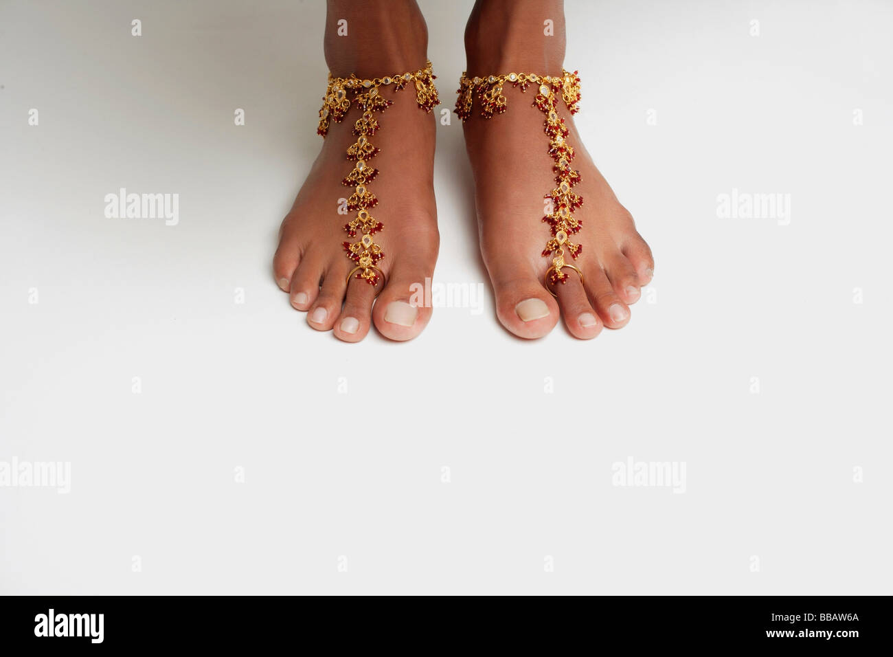 Donna di piedi con anklet contro il pavimento bianco Foto Stock