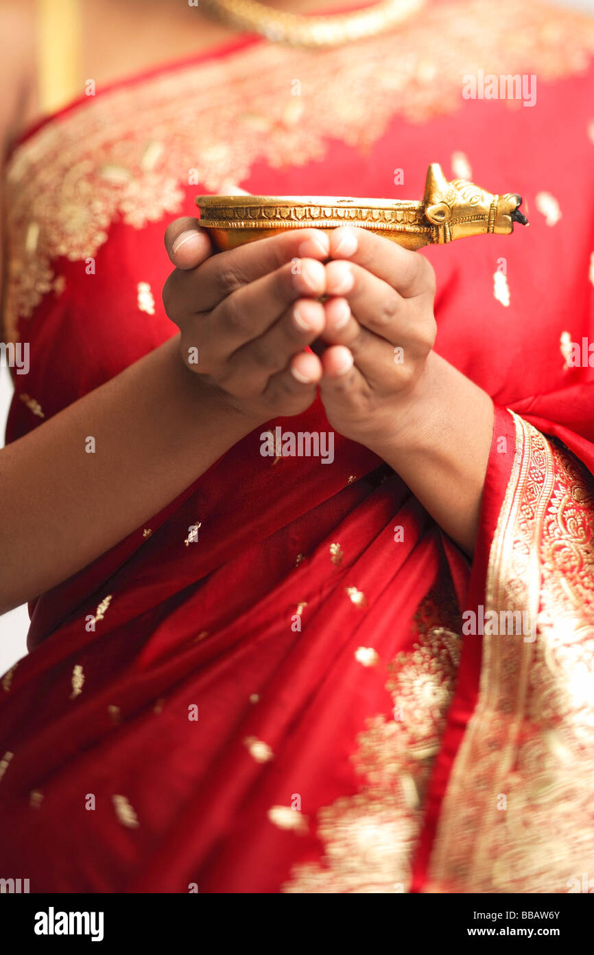 Donna in sari azienda olio lampada, immagine ritagliata Foto Stock
