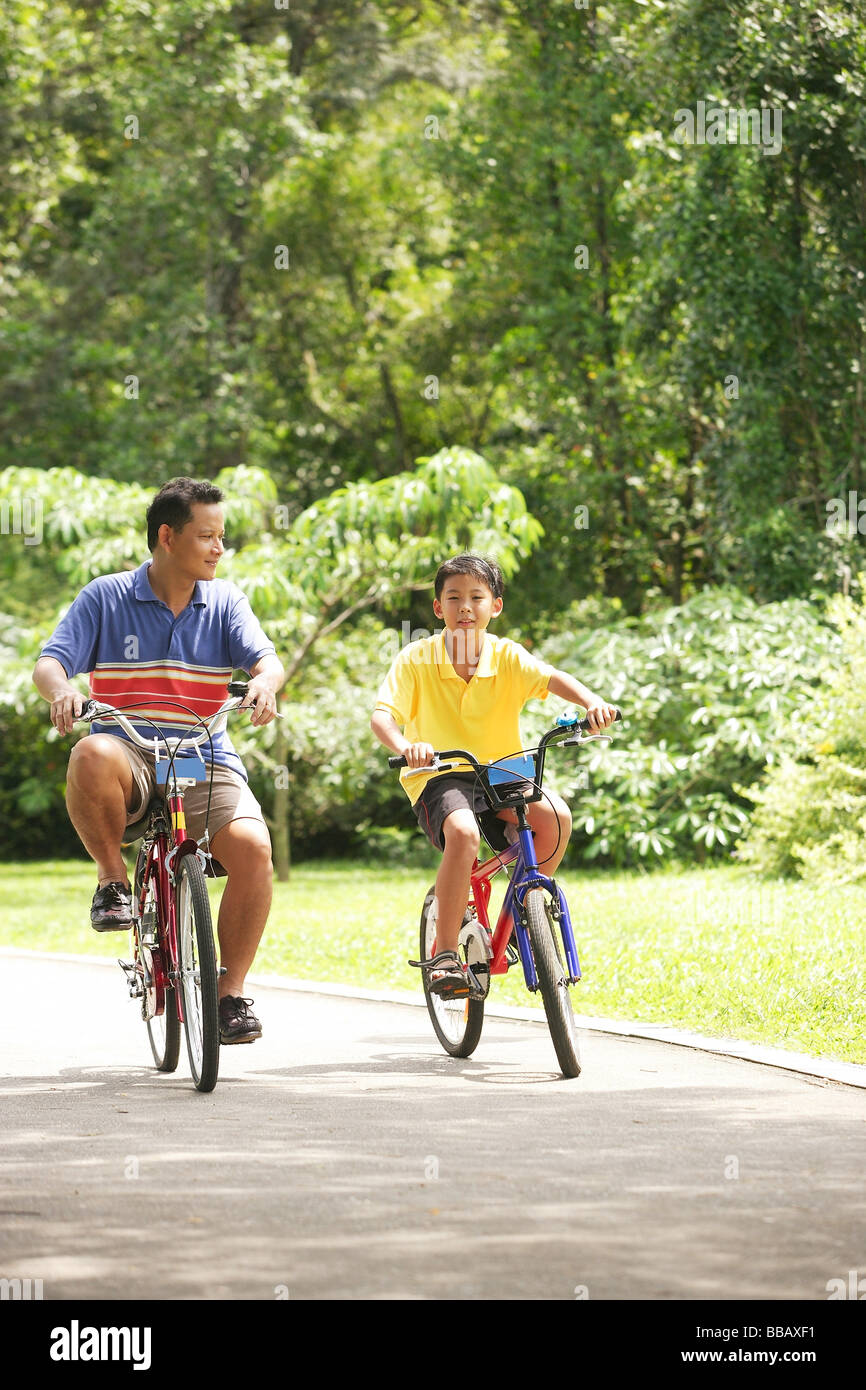 Padre e figlio in bicicletta, fianco a fianco Foto Stock