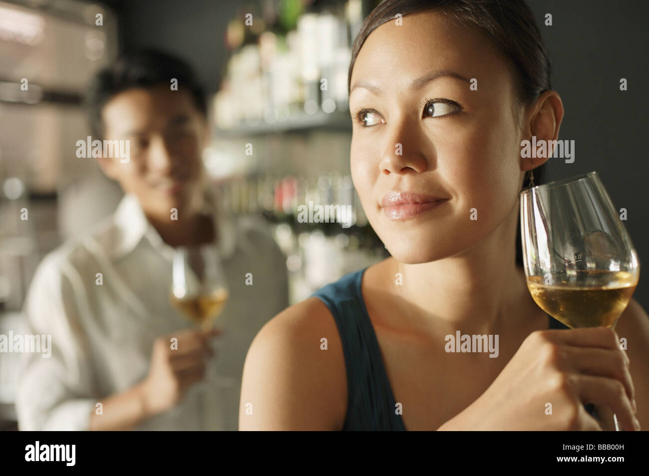 Donna che mantiene un drink e un uomo in background Foto Stock