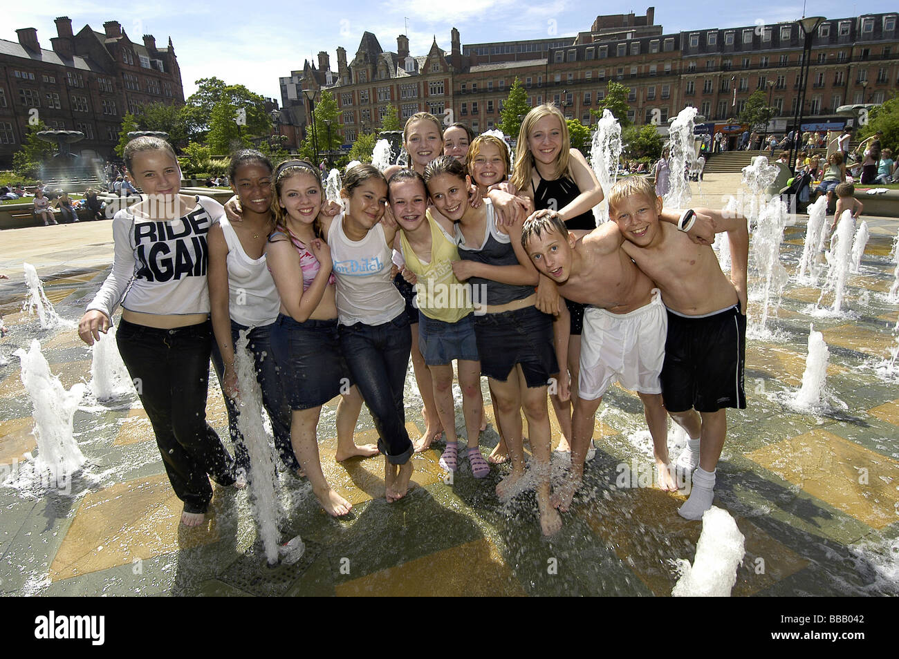 Gruppo di giovani costituiscono per la fotocamera con le fontane di Sheffield del centro città Foto Stock