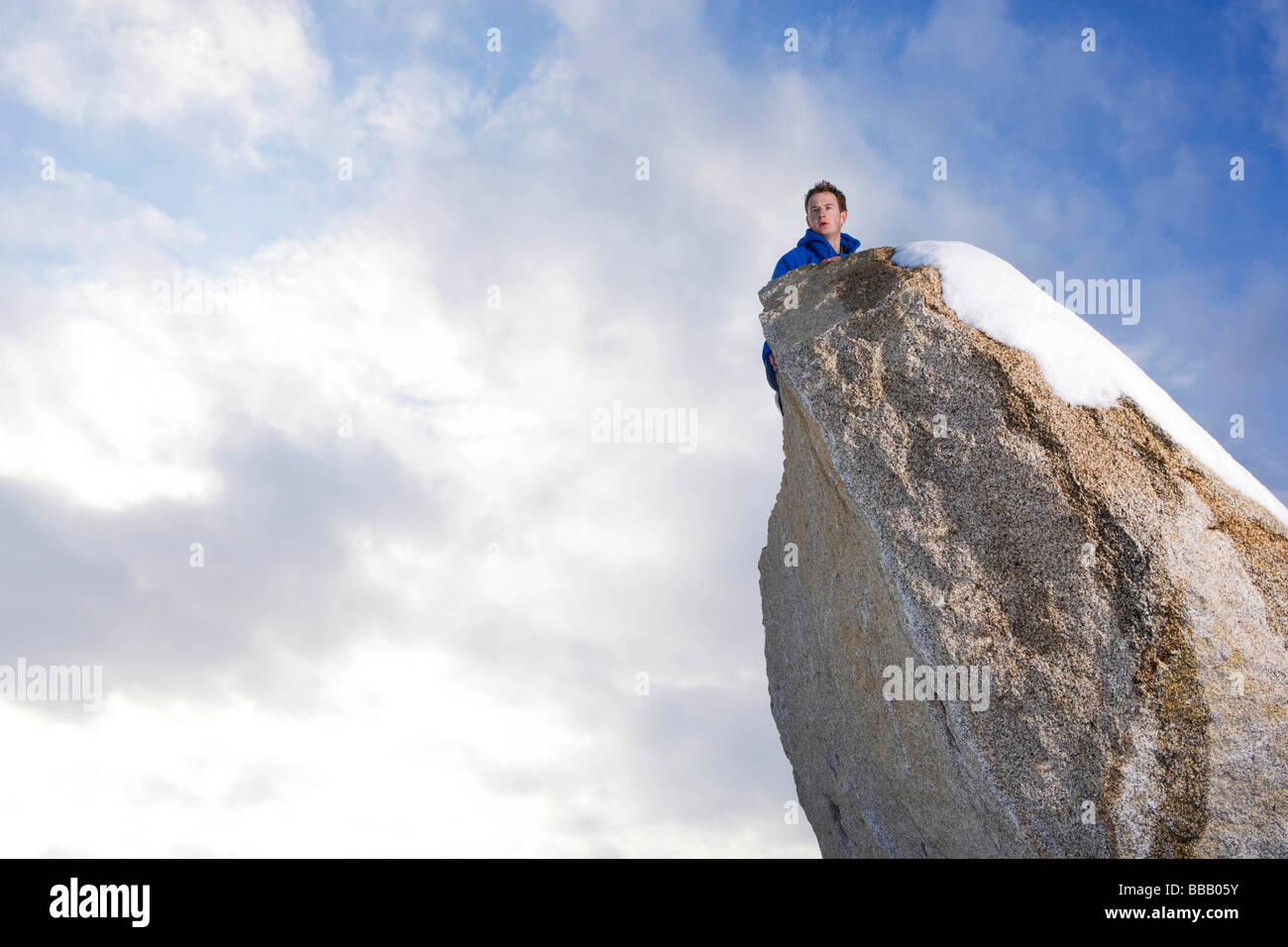 Uomo che guarda oltre il picco coperto di neve Foto Stock