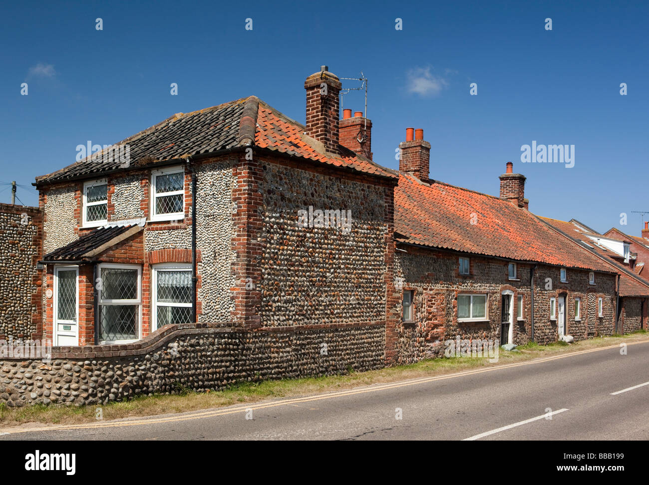 Regno Unito Inghilterra Norfolk Paston flint pebble cottage di fronte al fianco di vecchia terrazza di case basse Foto Stock