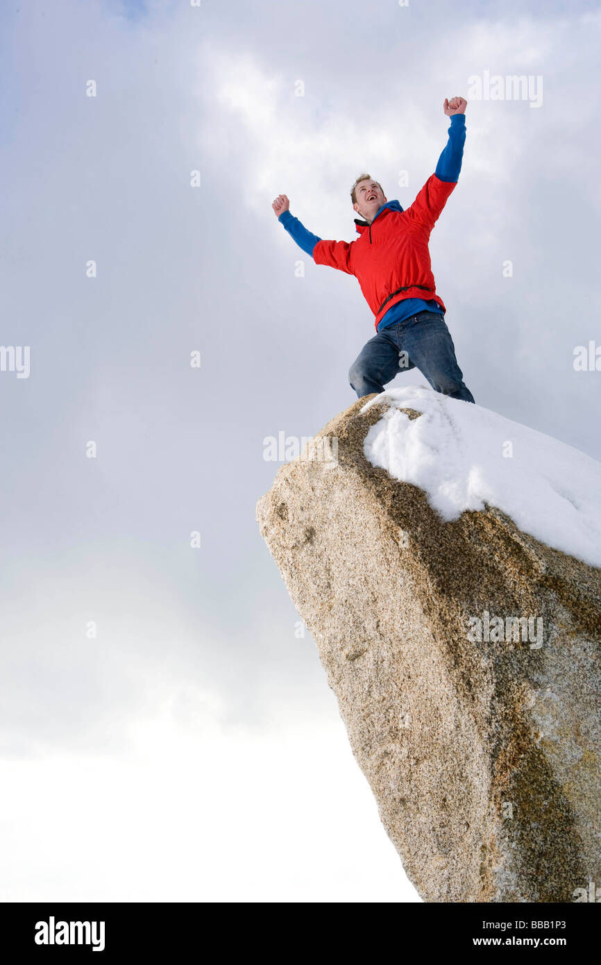 Scalatore celebrando in Snow capped peak Foto Stock
