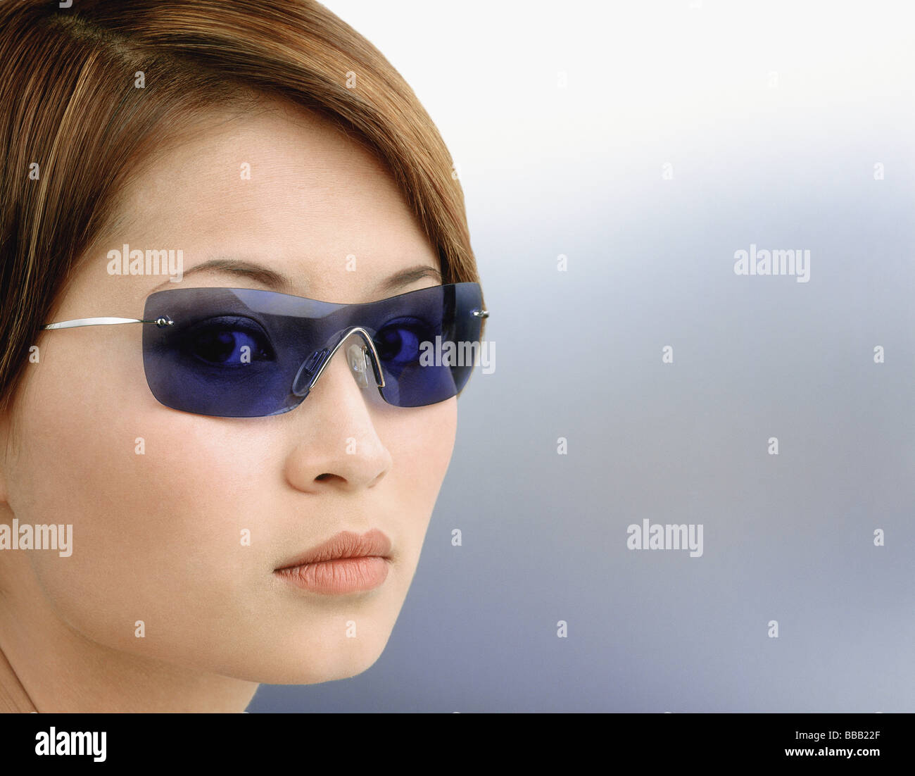 Giovane donna blu da indossare occhiali da sole oscurata, ritratto Foto Stock