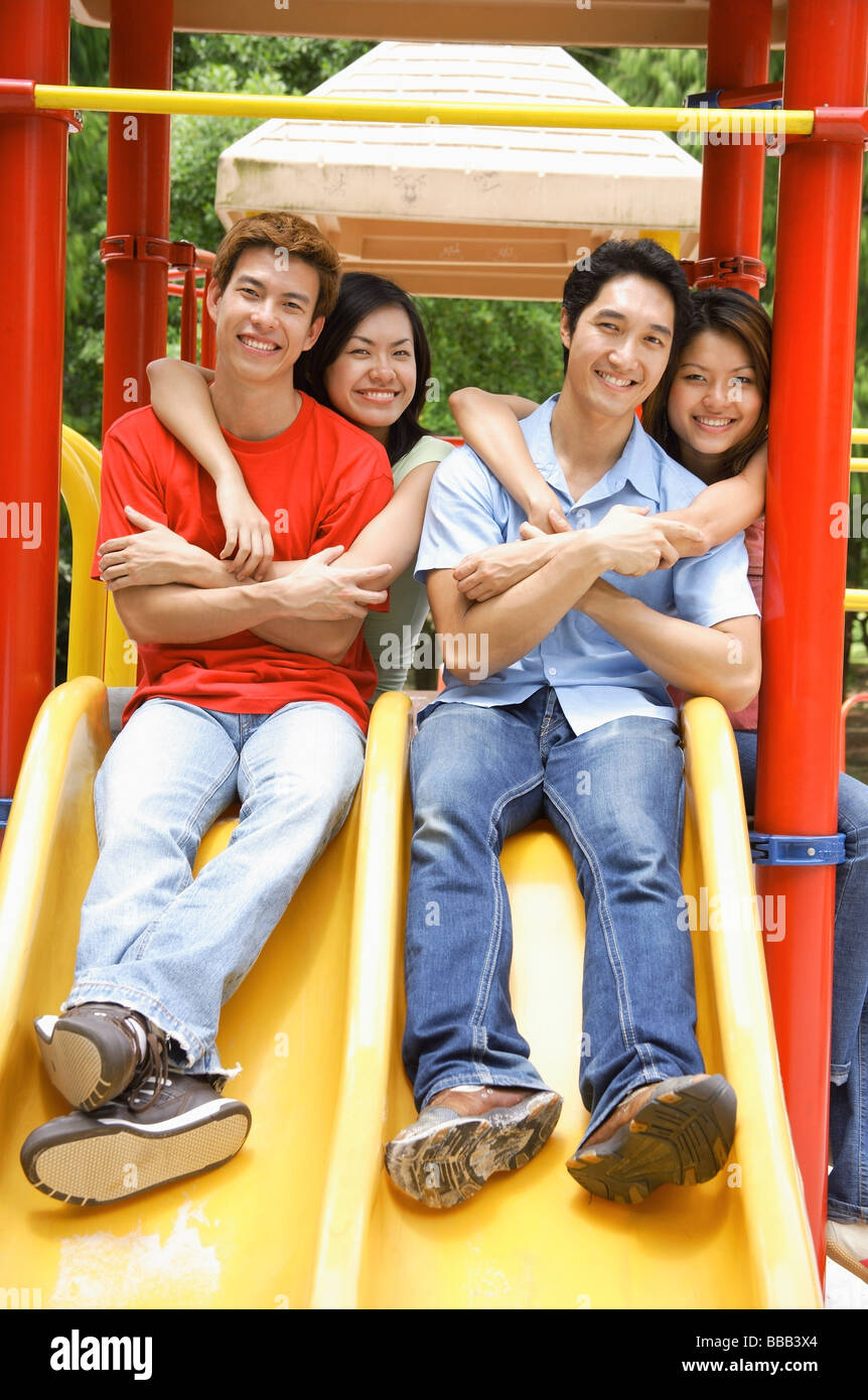 I giovani adulti nel parco giochi, sorridente in telecamera, ritratto Foto Stock
