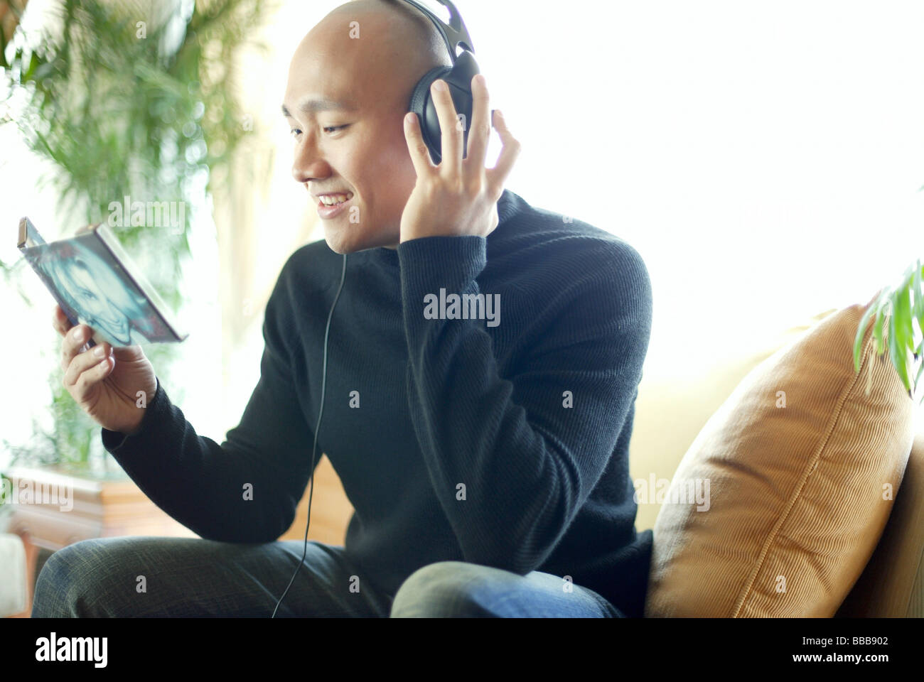 Man in Black turtleneck, con cuffie e ascolto di musica Foto Stock