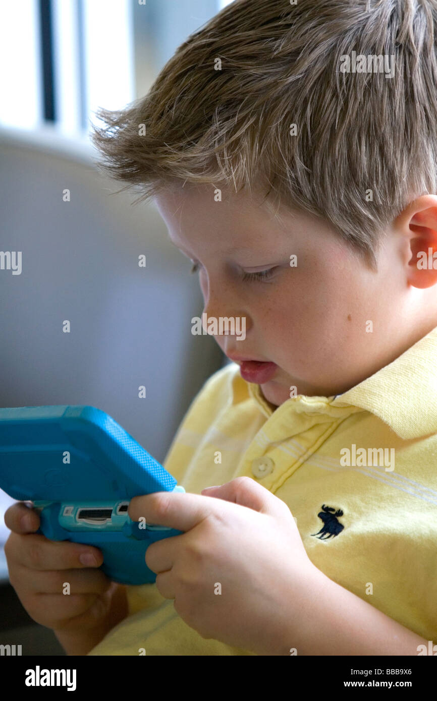 Ragazzo giocando con un personale sistema di video gioco presso l'Aeroporto di Boise Idaho USA MR Foto Stock