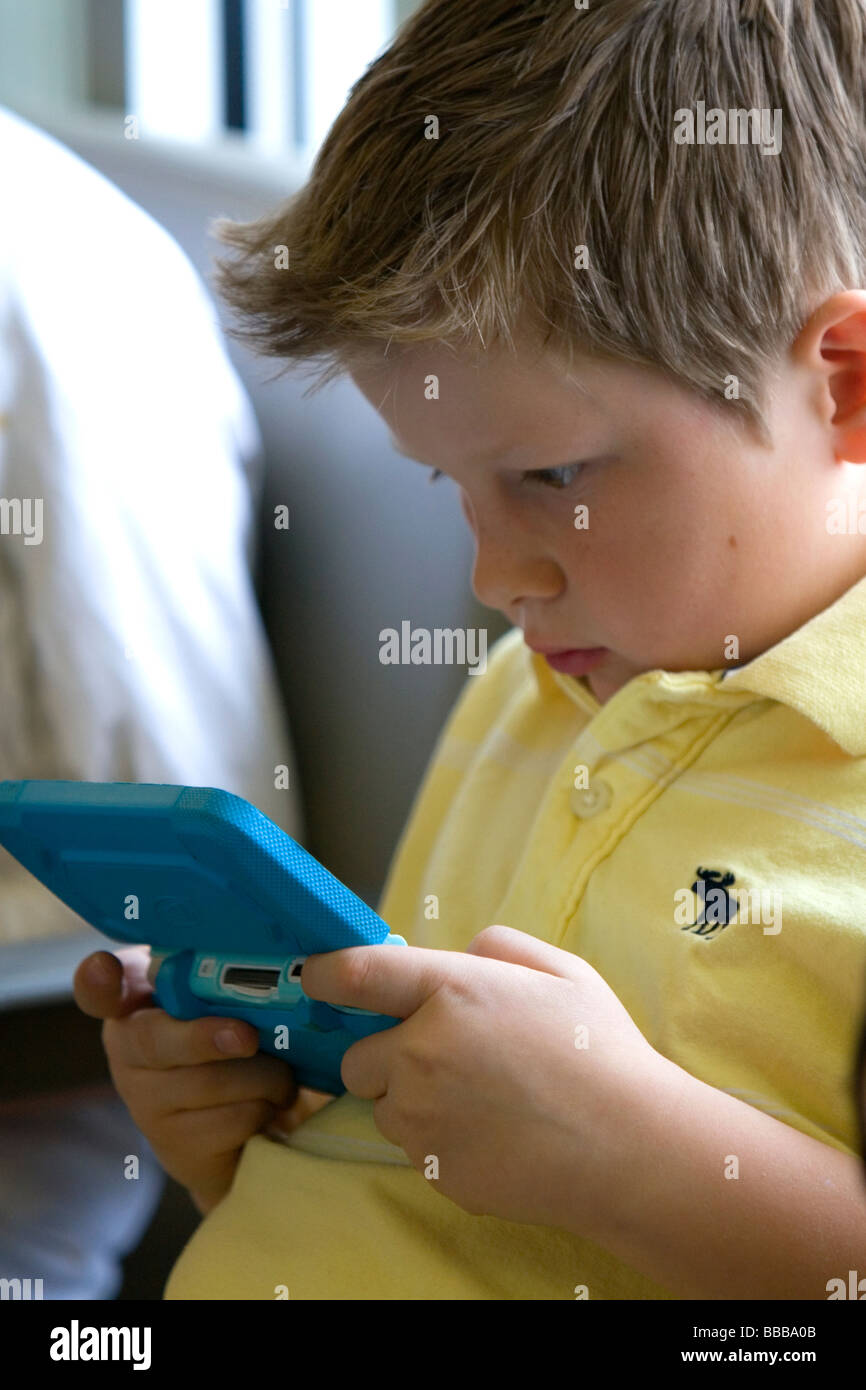 Ragazzo giocando con un personale sistema di video gioco presso l'Aeroporto di Boise Idaho USA MR Foto Stock