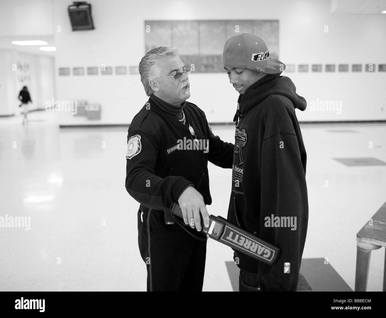 Una guardia di sicurezza controlla uno studente con un rivelatore di metalli a New Haven Connecticut USA di alta scuola Foto Stock