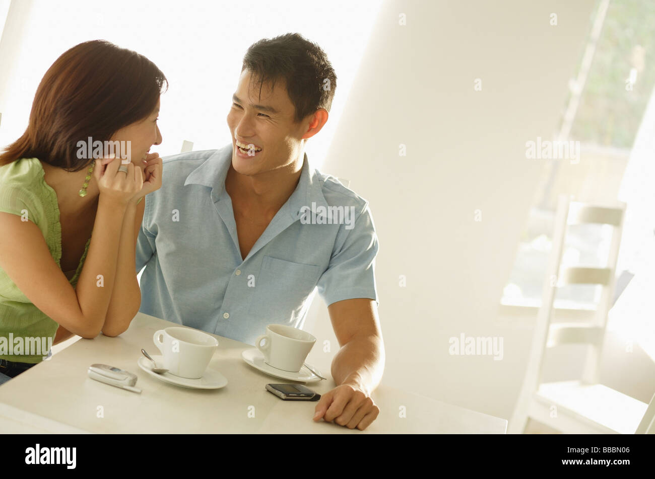 Giovane seduto presso il cafe, affiancate , sorridente Foto Stock