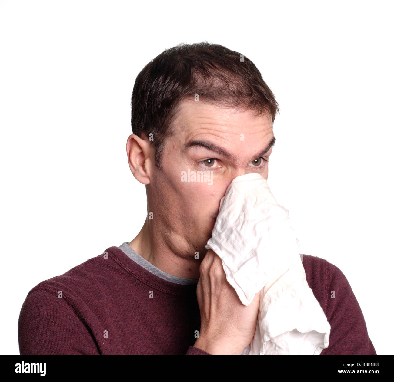 L'uomo soffia il naso in un fazzoletto Foto Stock