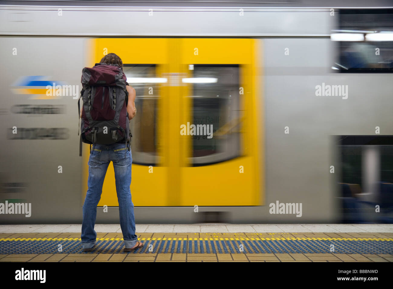 Un backpacker attende a bordo di un treno in stazione piattaforma. Foto Stock
