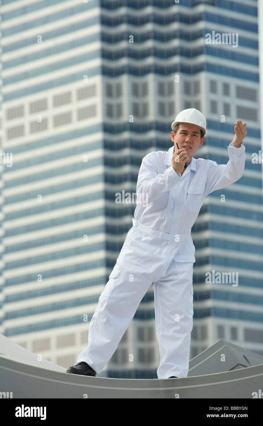 Uomo con walkie talkie dare indicazioni Foto Stock