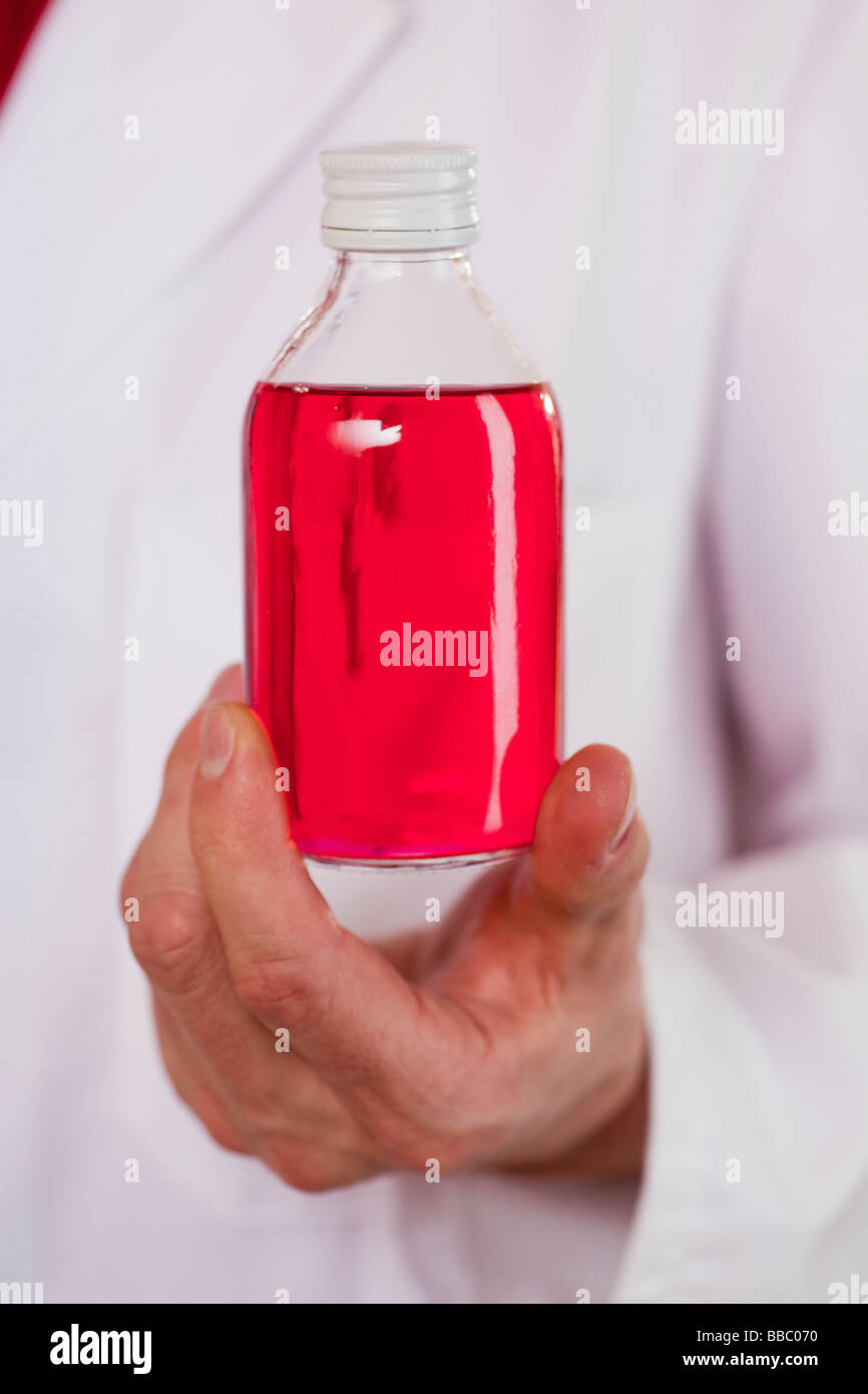 Mano che tiene la bottiglia di medicina Foto Stock