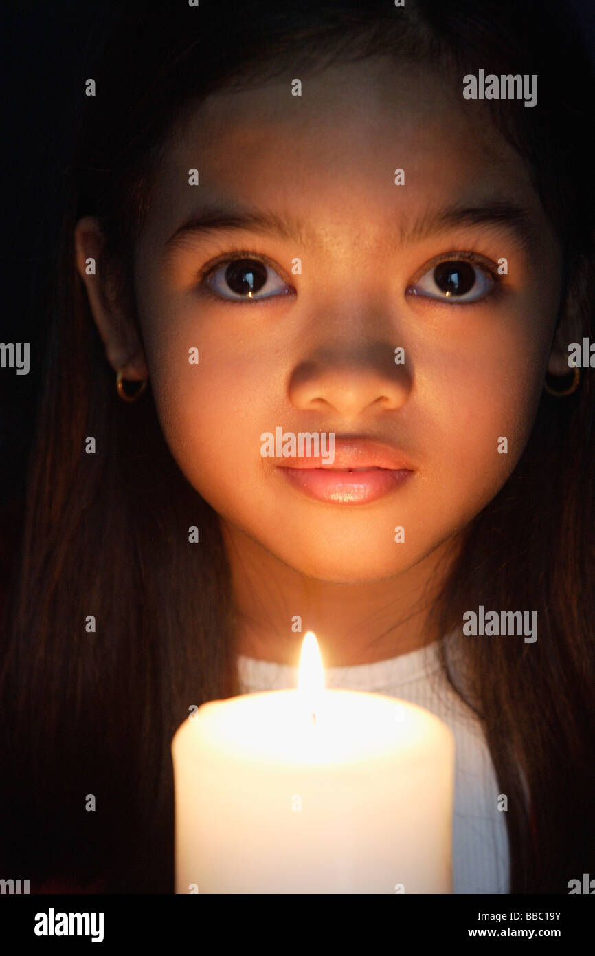 Ragazza con candela guardando la fotocamera Foto Stock