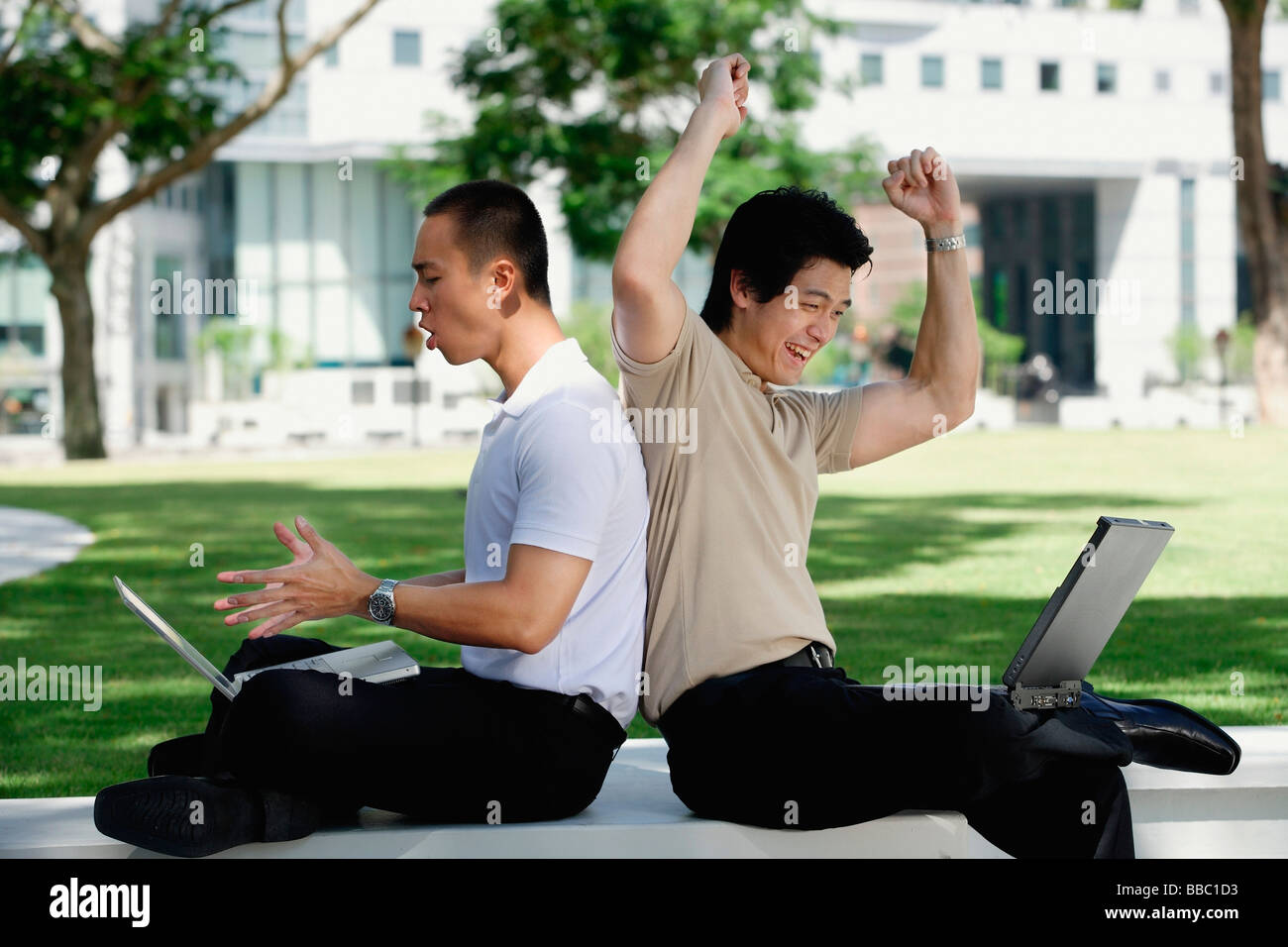 Due uomini utilizzano i laptop nel parco Foto Stock