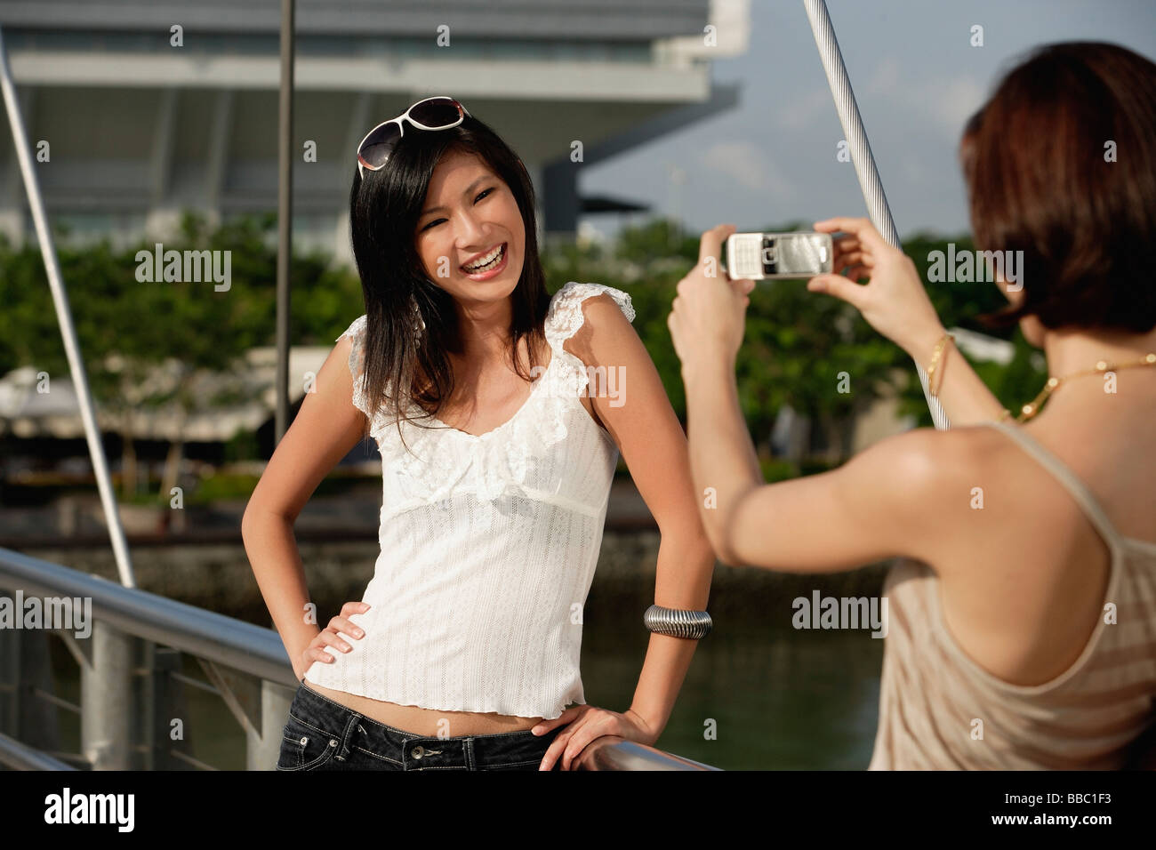 Gli amici di scattare foto di ogni altro su un ponte Foto Stock