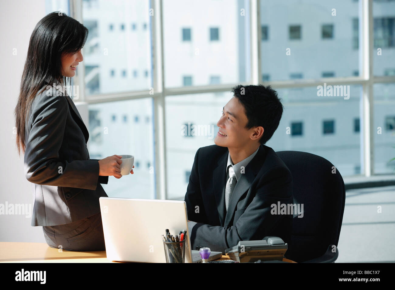 Due colleghi sorriso come parlano tra di loro Foto Stock