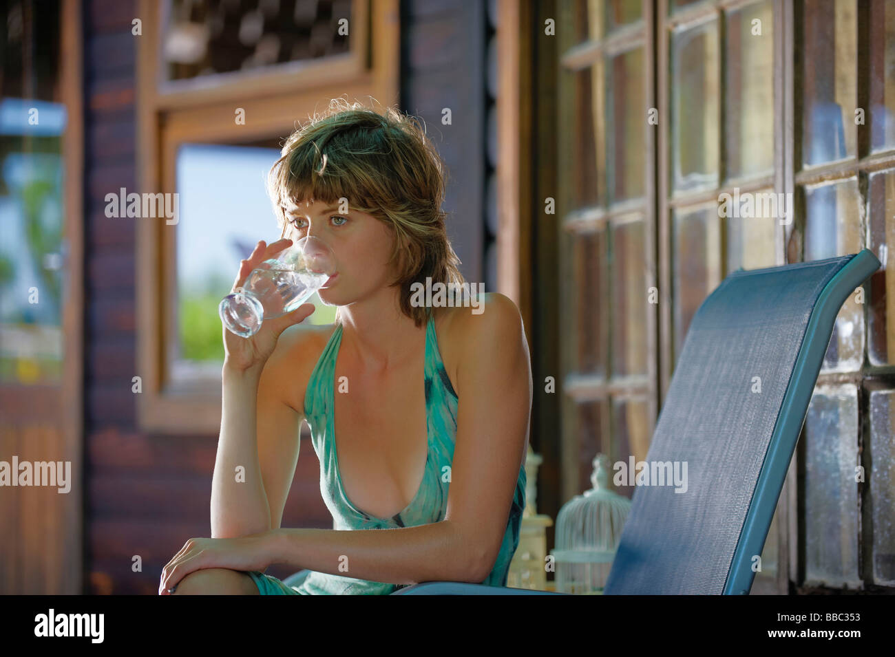 Giovane donna acqua potabile sulla veranda Foto Stock