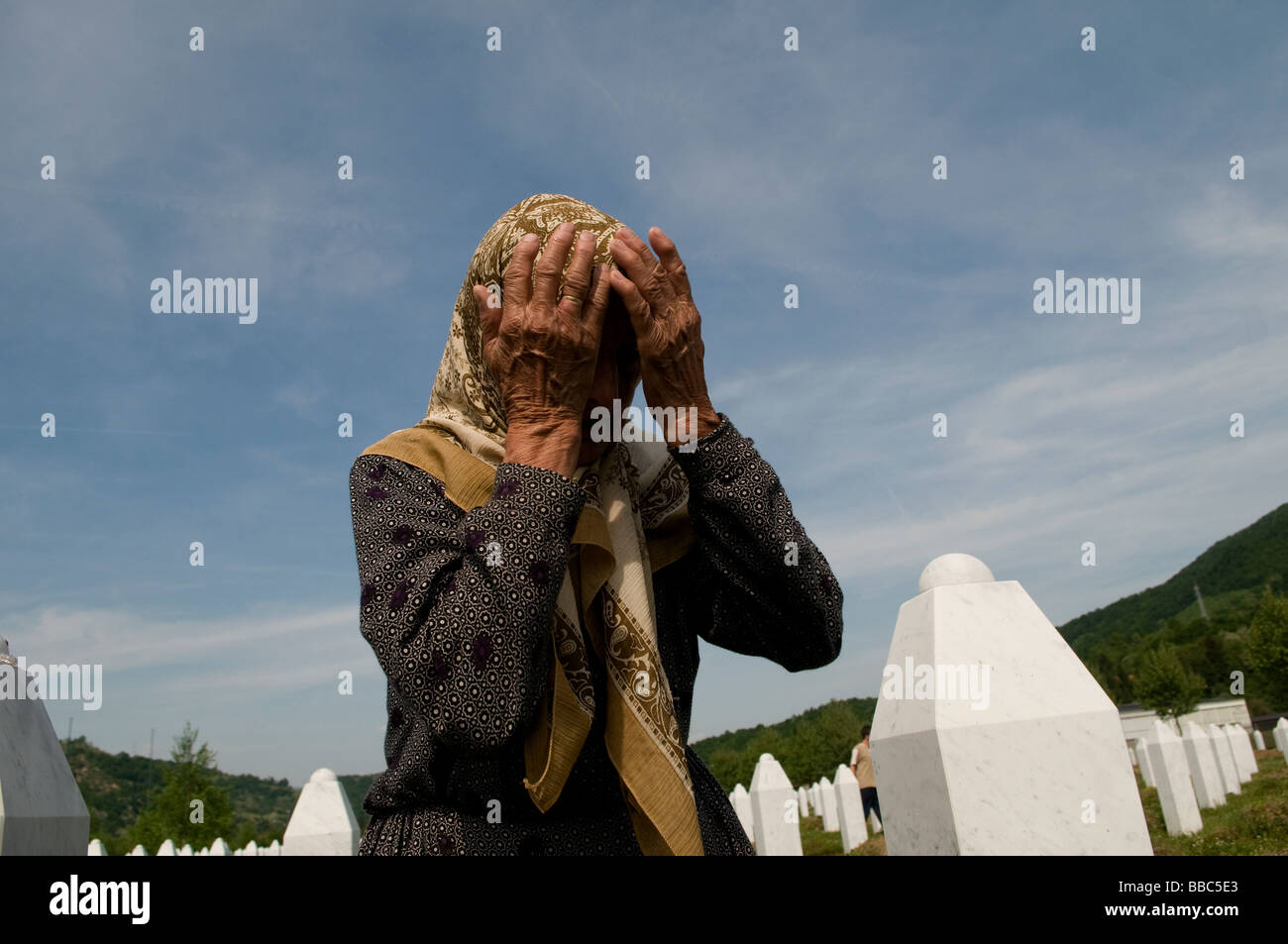 Una donna musulmana bosniaca piange tra tombe dei suoi parenti, vittime del genocidio Srebrenica, nel cimitero di Potocari, vicino a Srebrenica, in Bosnia Foto Stock