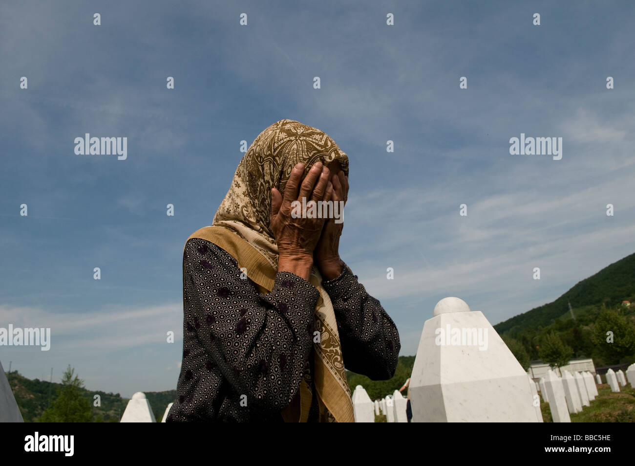 Una donna musulmana bosniaca piange tra tombe dei suoi parenti, vittime del genocidio Srebrenica, nel cimitero di Potocari, vicino a Srebrenica, in Bosnia Foto Stock