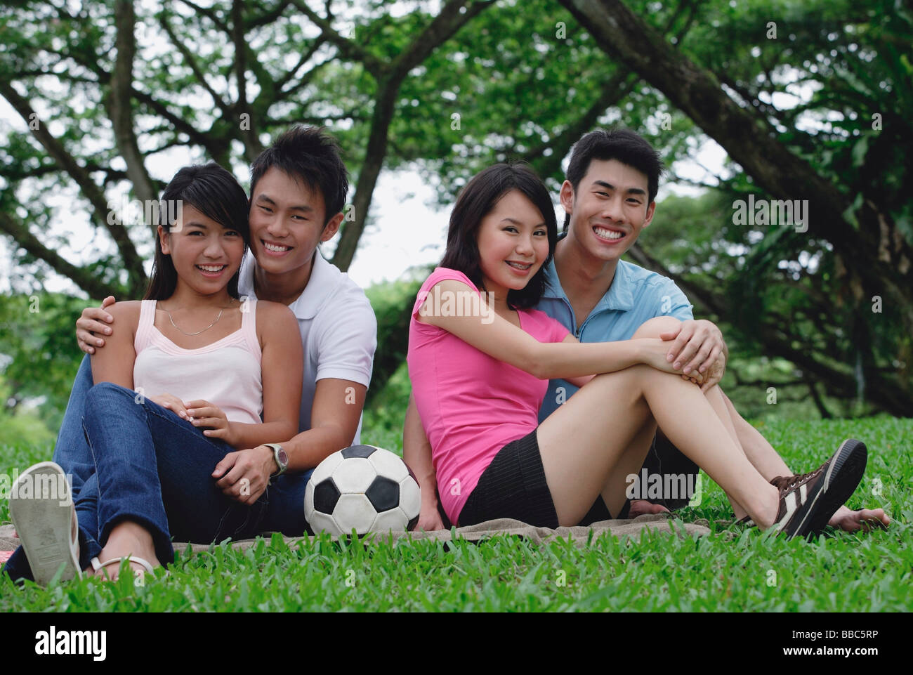I giovani adulti nel parco, sorridente in telecamera Foto Stock