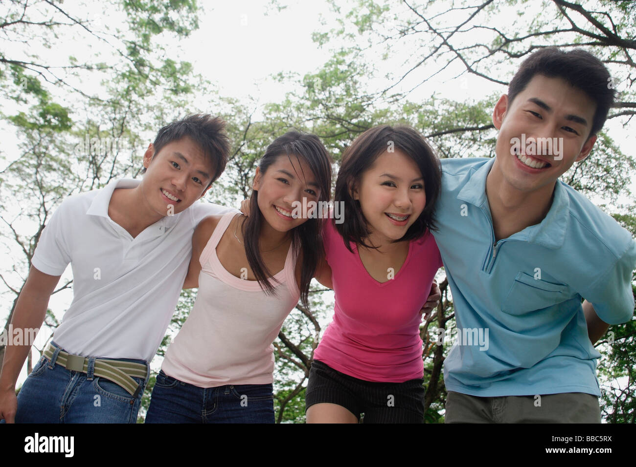 I giovani adulti nel parco, sorridente in telecamera Foto Stock