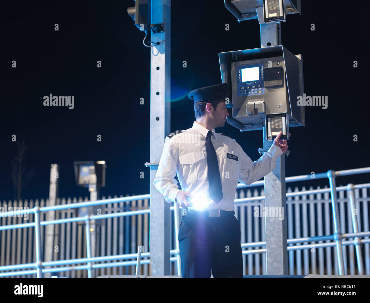 La guardia di sicurezza al cancello con torcia Foto Stock