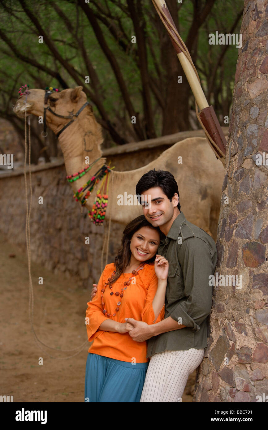 Coppia giovane abbracciando, camel in background Foto Stock