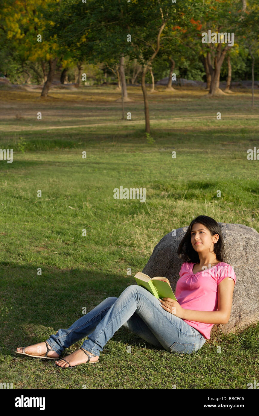 Teen lettura della ragazza prenota in posizione di parcheggio Foto Stock