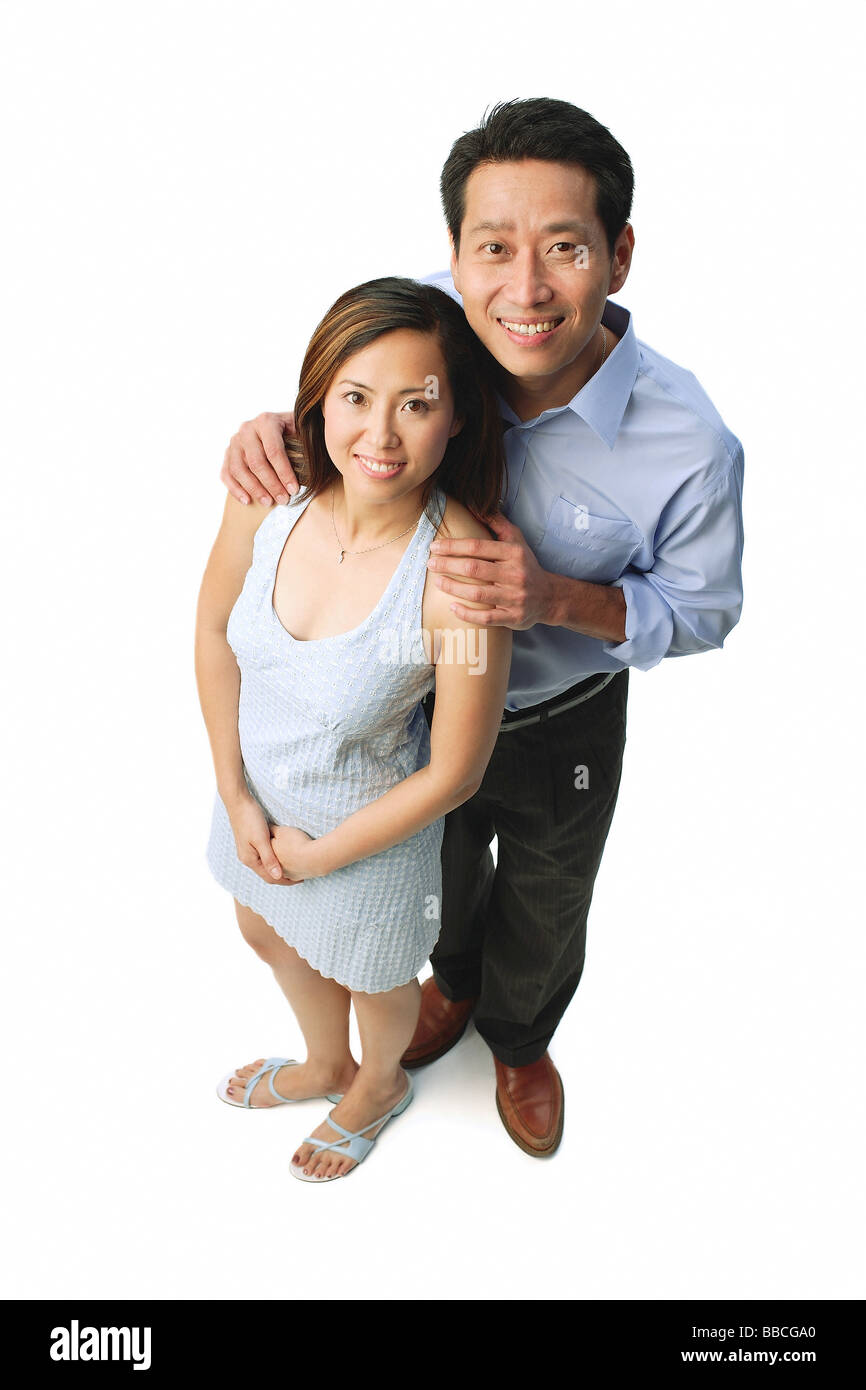 Matura in piedi a fianco a fianco, sorridente in telecamera Foto Stock