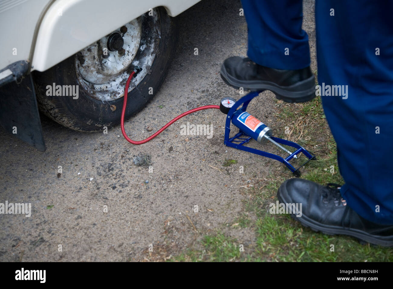 Il pompaggio di un pneumatico con una pompa a pedale Foto Stock