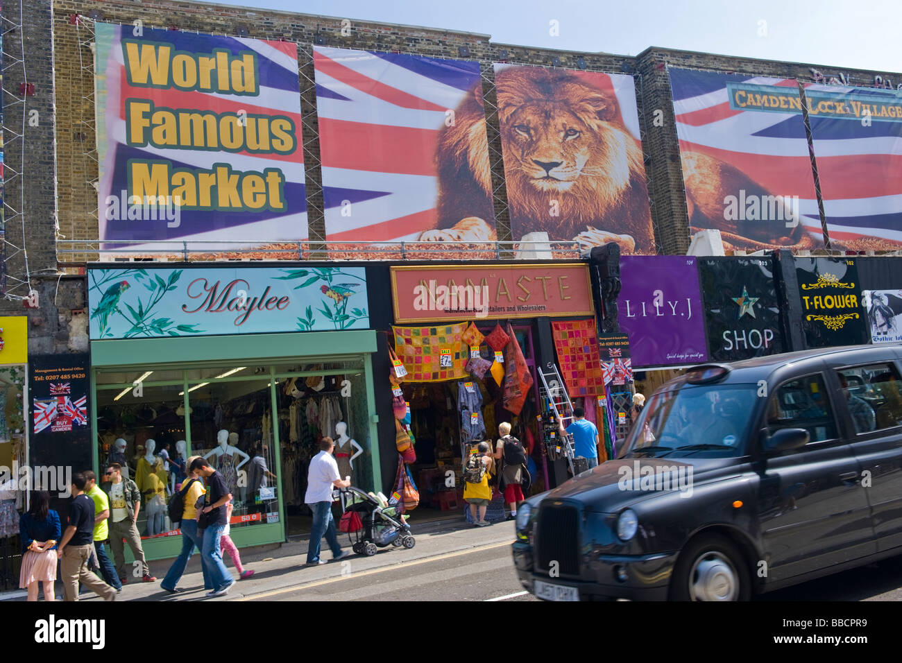 Camden Lock Village , stalle di Camden Market , taxi passato unità ricostruita la sezione del mercato dopo il fuoco con i nuovi negozi e folle Foto Stock