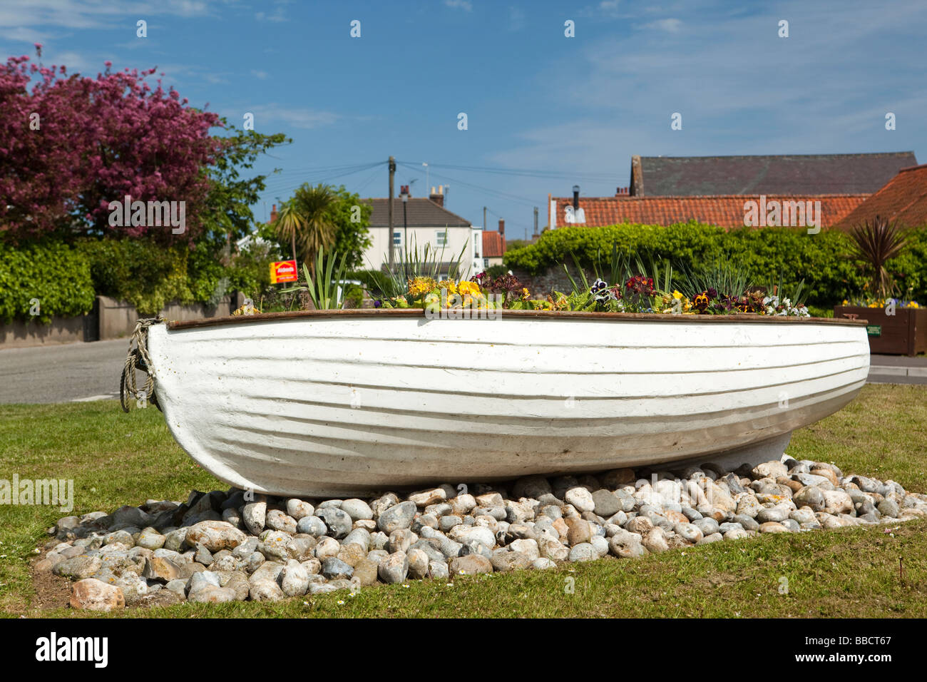 Regno Unito Inghilterra Norfolk Winterton sul paesino di mare dipinto di bianco di barca con fiori Foto Stock