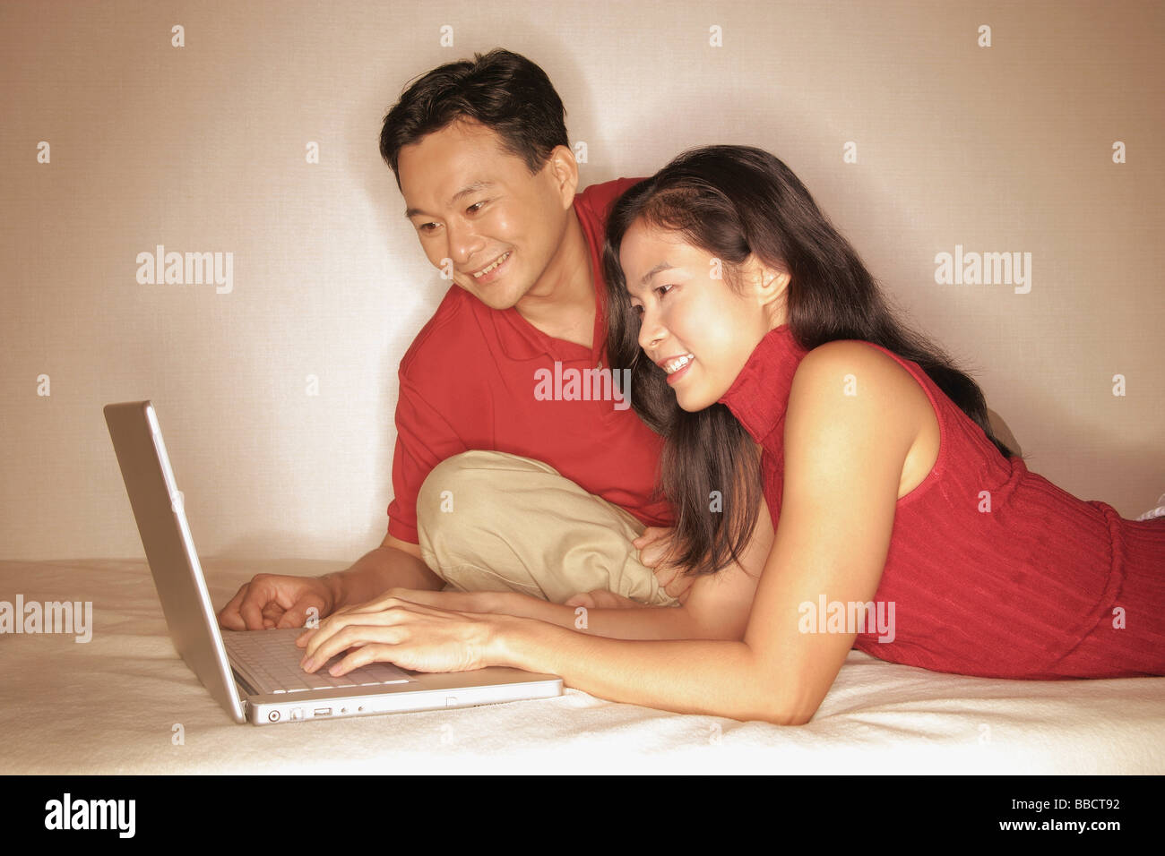 L uomo e la donna a fianco a fianco, utilizzando laptop Foto Stock
