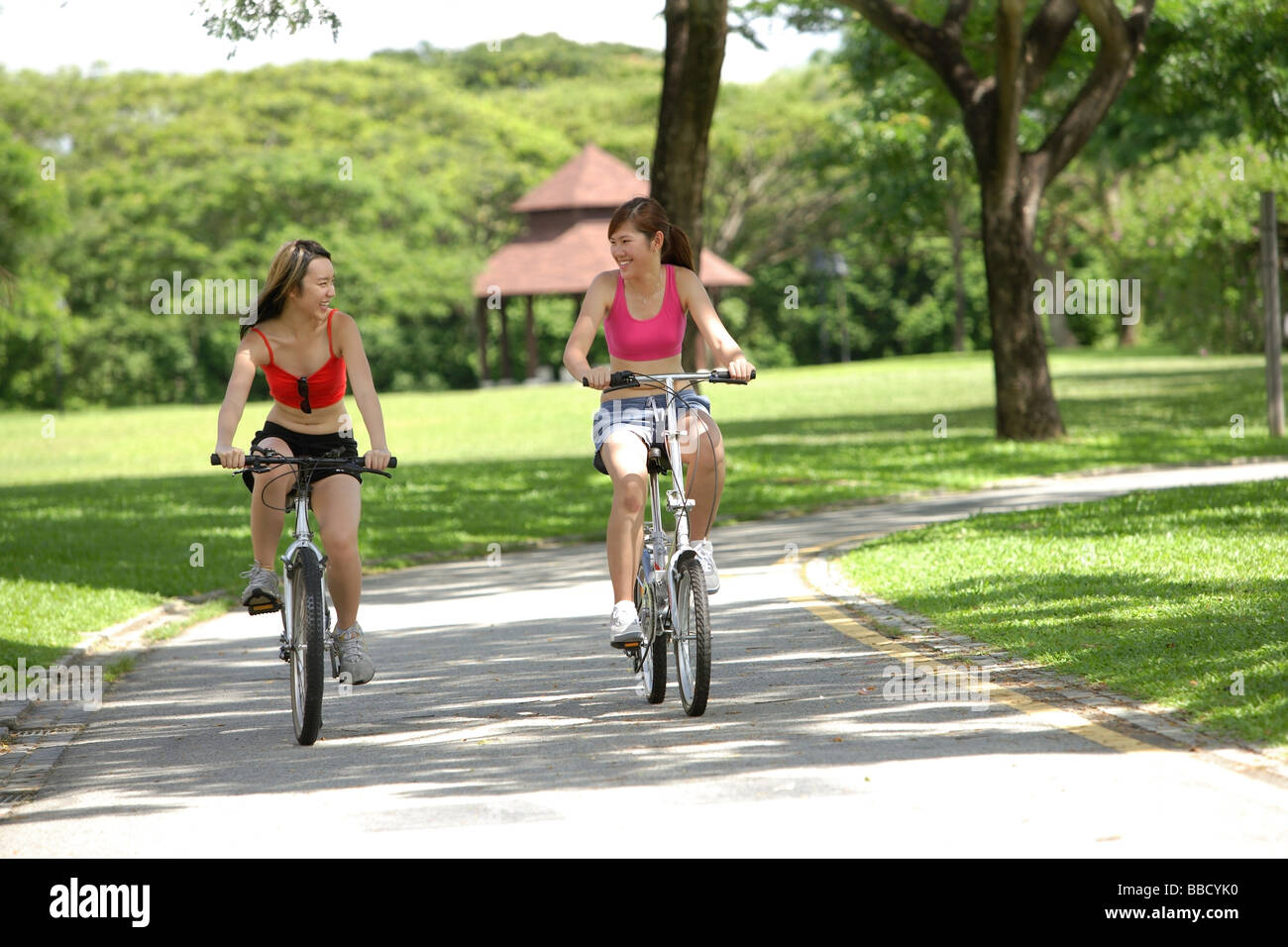 Due donne in bicicletta a fianco a fianco Foto Stock