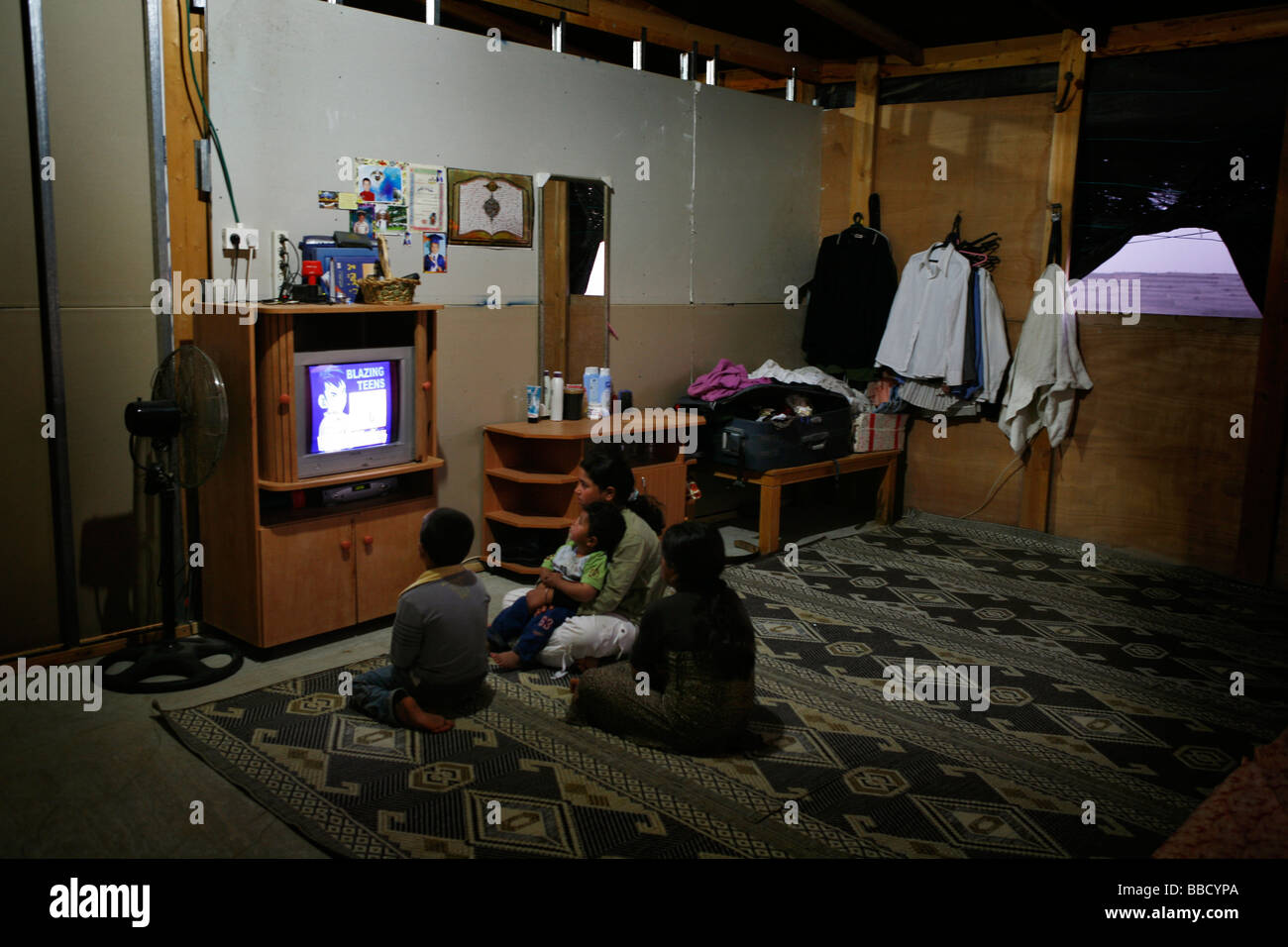 I bambini guardare la TV in casa loro. Un generatore garantisce una fornitura di energia elettrica dalle 7 pm alle 7 am. El Araqeeb, Israele Foto Stock